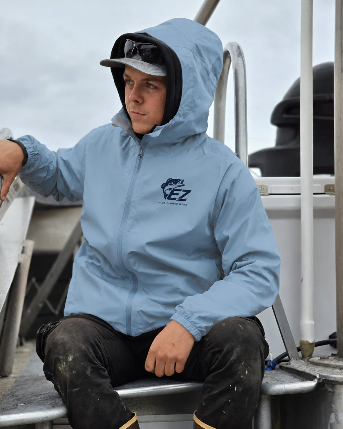 Angler wearing a light blue EZ Fishing Wear jacket on a boat