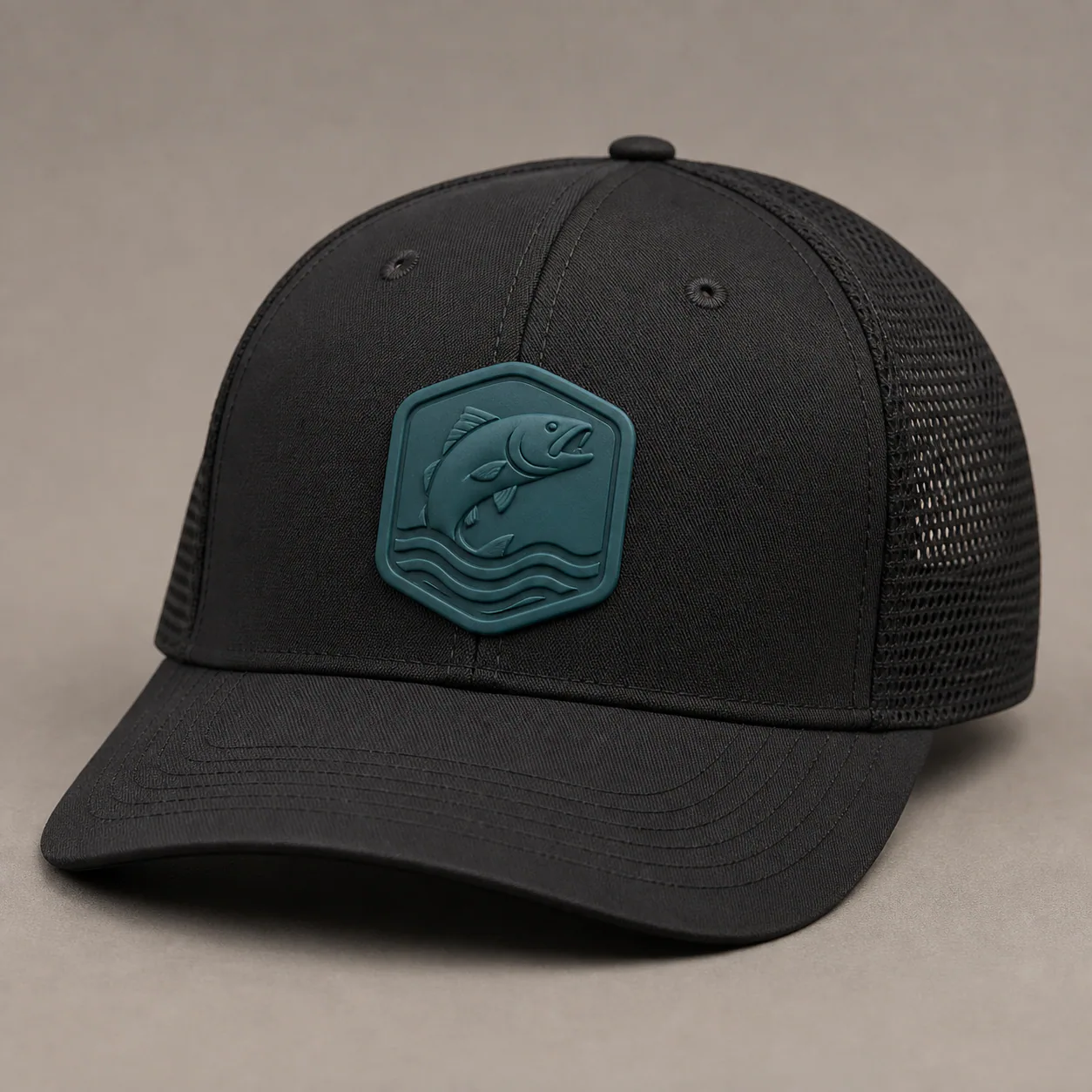 Black fishing cap with a raised teal silicone fish badge